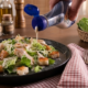 Molho para salada Castelo servido com folhas verdes, legumes e grãos