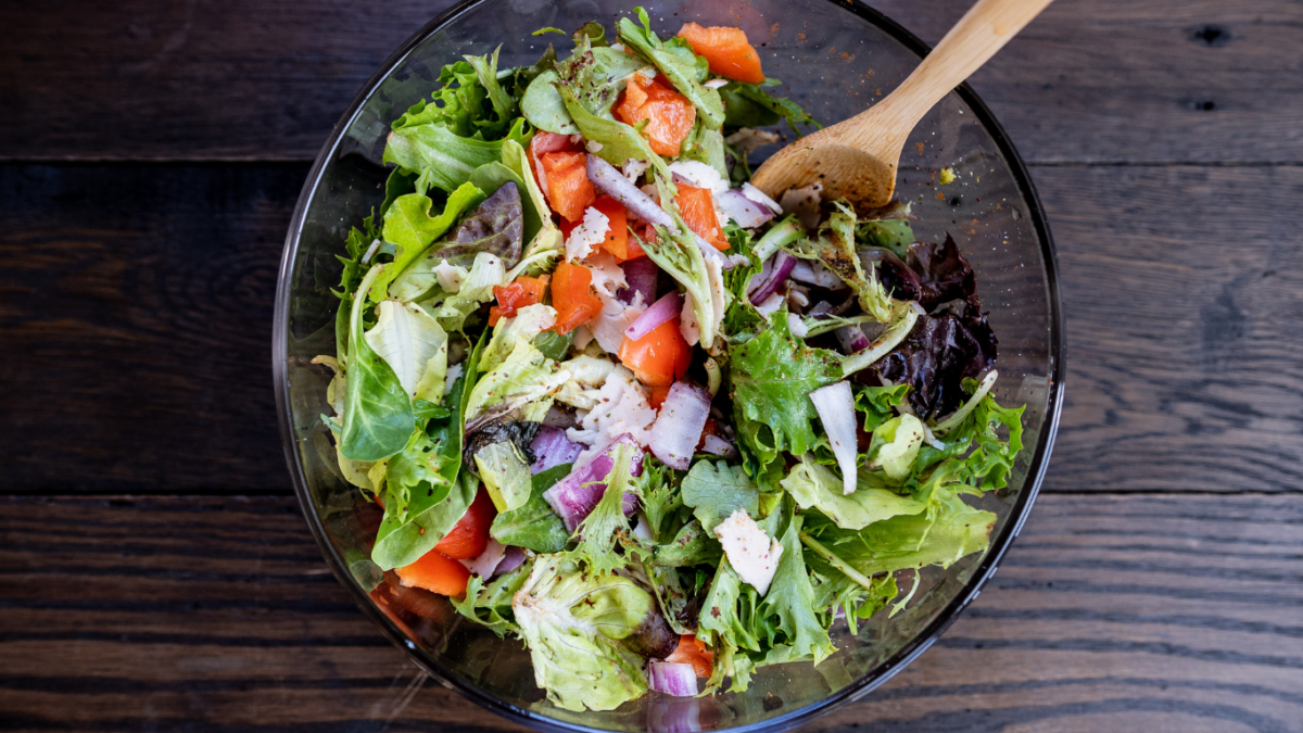 Salada como prato principal com frango grelhado, folhas variadas e molho caesar