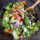 Salada como prato principal com frango grelhado, folhas variadas e molho caesar