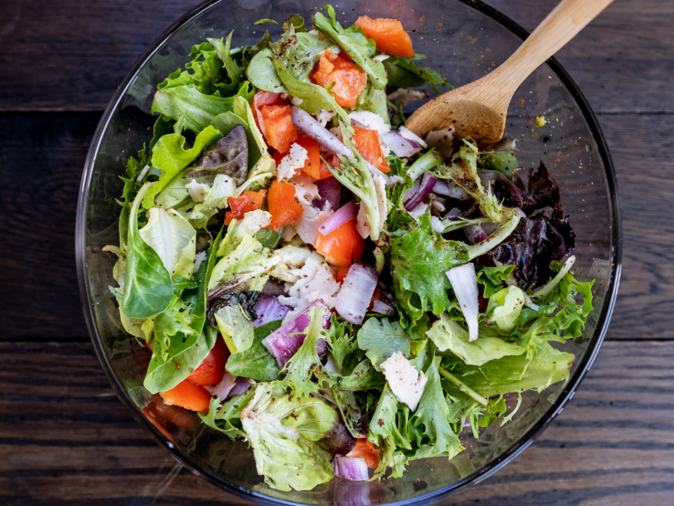 Salada como prato principal com frango grelhado, folhas variadas e molho caesar