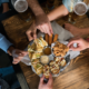 Mesa de happy hour com petiscos variados: bolinhos, dadinhos de tapioca e molhos para compartilhar