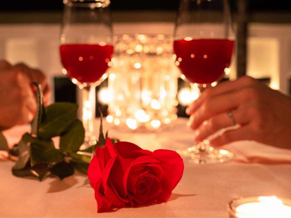 Mesa romântica posta para o jantar de Dia dos Namorados com velas, flores e pratos da culinária internacional