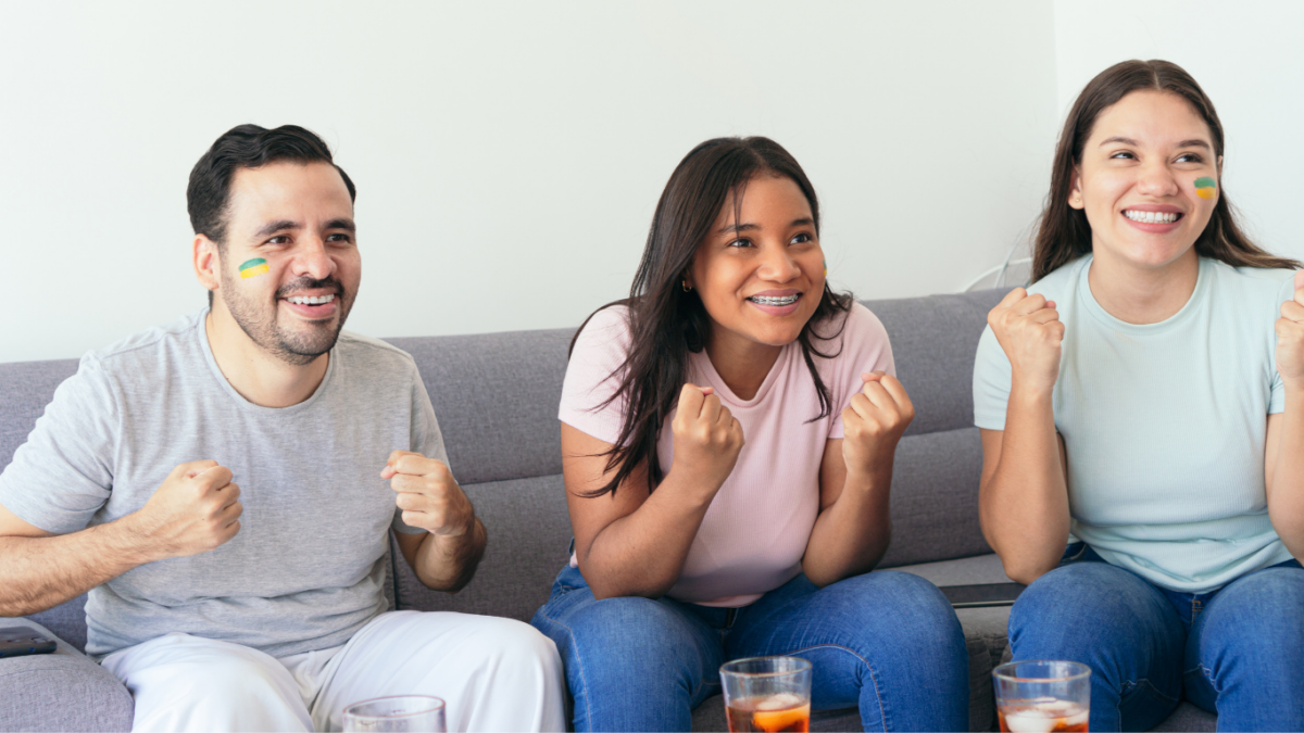 Pessoas reunidas para assistir aos jogos da Copa do Mundo, com espetinhos, chips e rolinhos