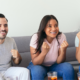 Pessoas reunidas para assistir aos jogos da Copa do Mundo, com espetinhos, chips e rolinhos