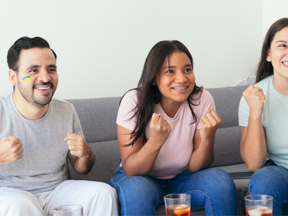 Pessoas reunidas para assistir aos jogos da Copa do Mundo, com espetinhos, chips e rolinhos