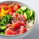 Bowl de poke de atum com arroz japonês, ingredientes frescos sobre a mesa