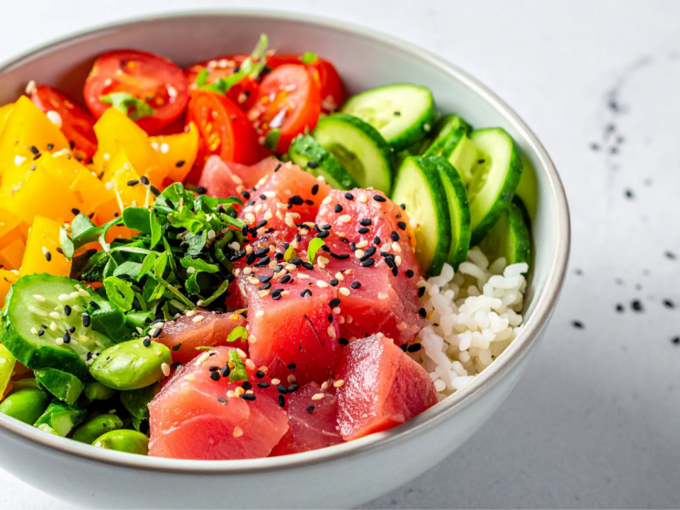 Bowl de poke de atum com arroz japonês, ingredientes frescos sobre a mesa