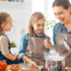Crianças na cozinha preparando receitas divertidas durante as férias de julho